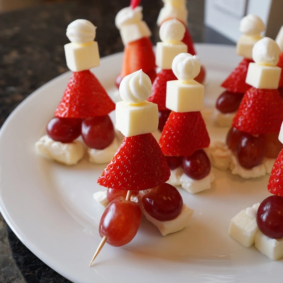 Bright red Santa Hat Fruit and Cheese Platter with white cheese, grapes, perfect for a holiday appetizer.