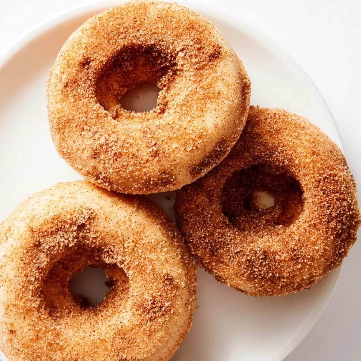 Warm, golden-brown cinnamon-sugar baked donuts, perfect for a sweet breakfast or snack, ready to enjoy.