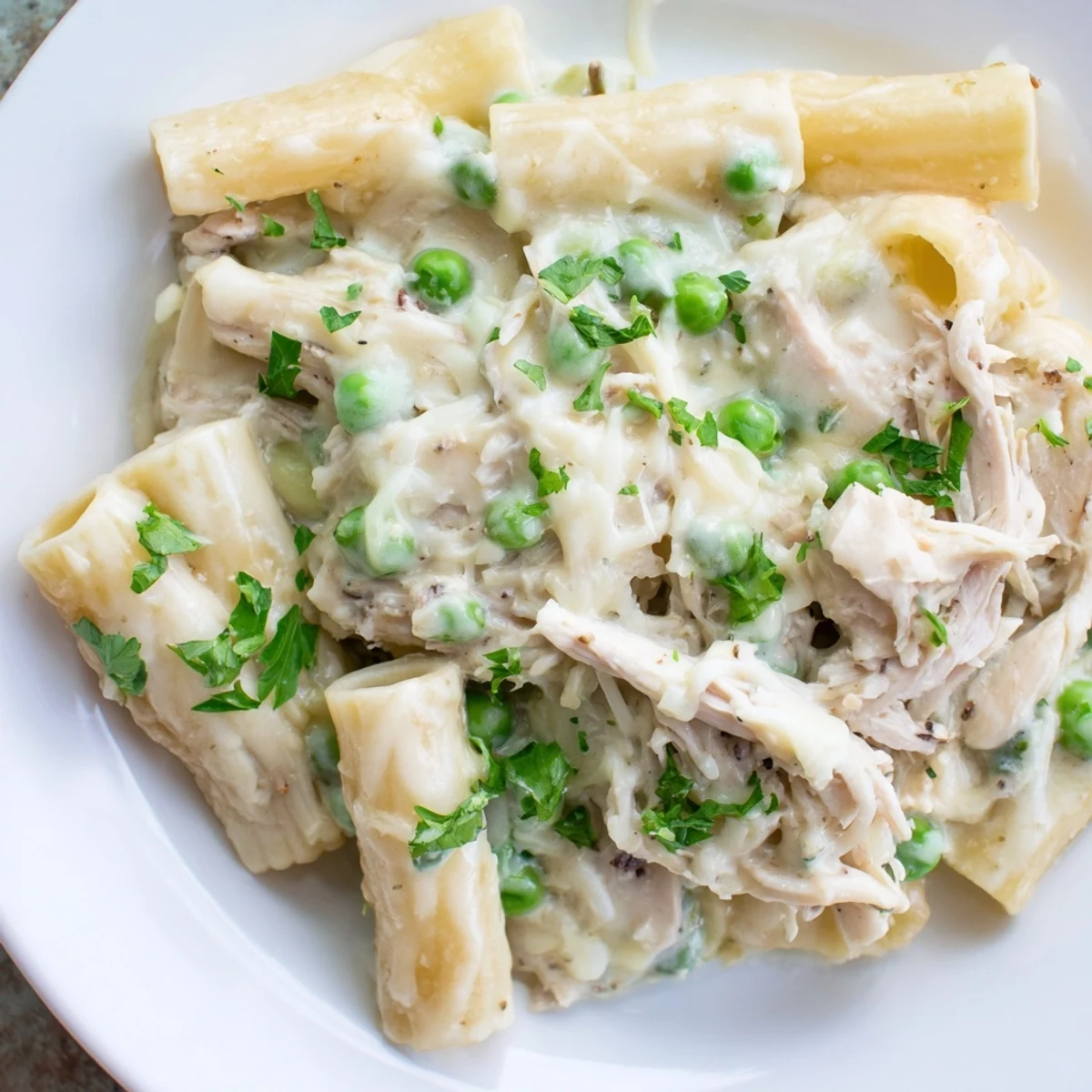 Enjoy a steaming plate of Slow Cooker Chicken Alfredo Pasta Bake, loaded with tender chicken and penne.