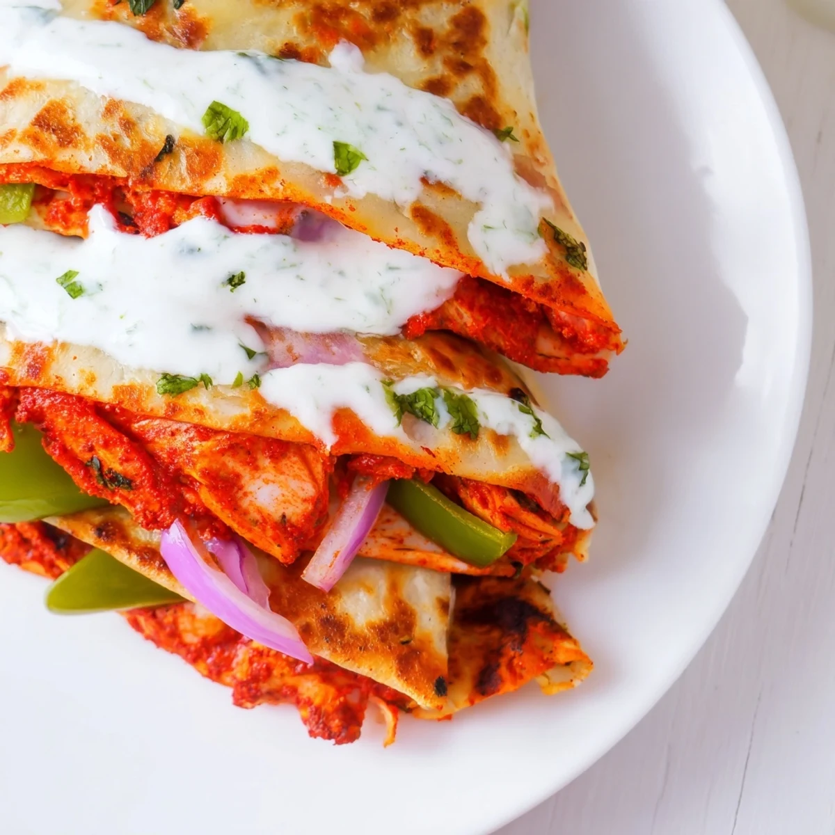 Golden-brown Tandoori Chicken Quesadilla, filled with juicy chicken, melted cheese, and fresh vegetables.