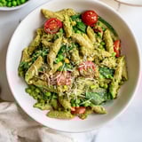 Tender, flavorful One-Pot Creamy Pesto Pea Protein Pasta ready to serve, garnished with Parmesan cheese.
