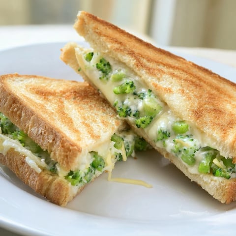 Golden and crispy air fryer broccoli cheddar stuffed grilled cheese, ready to satisfy a comfort food craving.