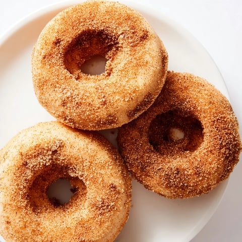 Warm, golden-brown cinnamon-sugar baked donuts, perfect for a sweet breakfast or snack, ready to enjoy.