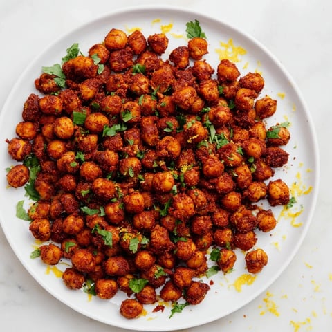 Golden, crispy harissa chickpea roast: a vegan snack radiating warmth and flavorful spice.