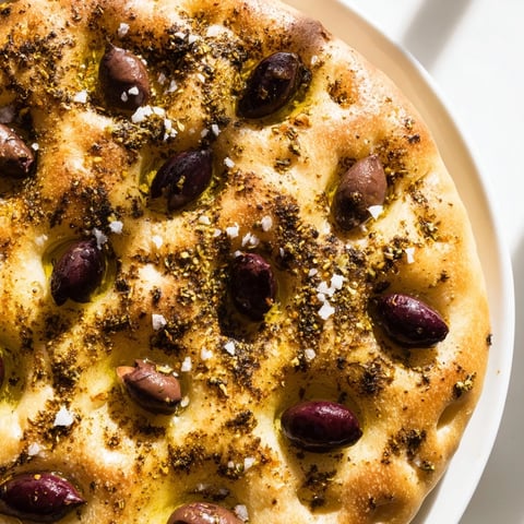 Warm, golden Zaatar Olive Focaccia, wonderfully dimpled, loaded with olives, and ready for serving a perfect Mediterranean flavor.