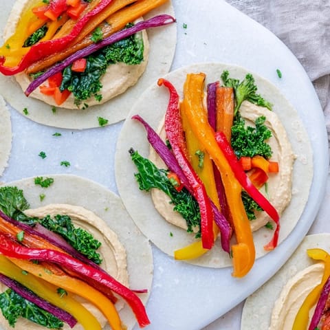 Vibrant photo showing delicious Roasted Veggie & Hummus Candy Cane Wrap roll-ups, a colorful and healthy snack.