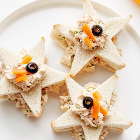Adorable Mini Starfish Sandwiches, ready to be devoured, with olive eyes and caper accents.