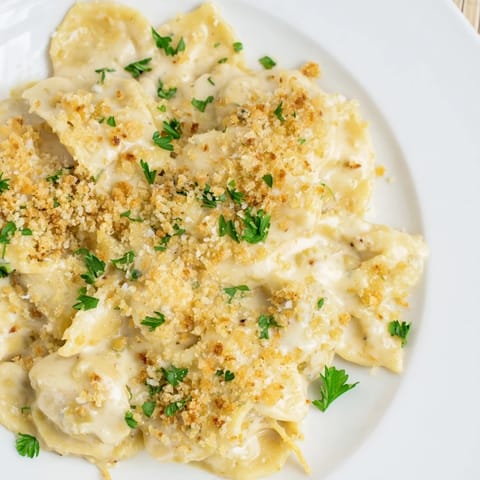 A bowl of high-protein mac & cheese, its rich, cheesy sauce clinging to pasta, delicious comfort food.
