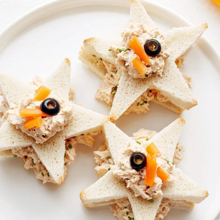 Adorable Mini Starfish Sandwiches, ready to be devoured, with olive eyes and caper accents.