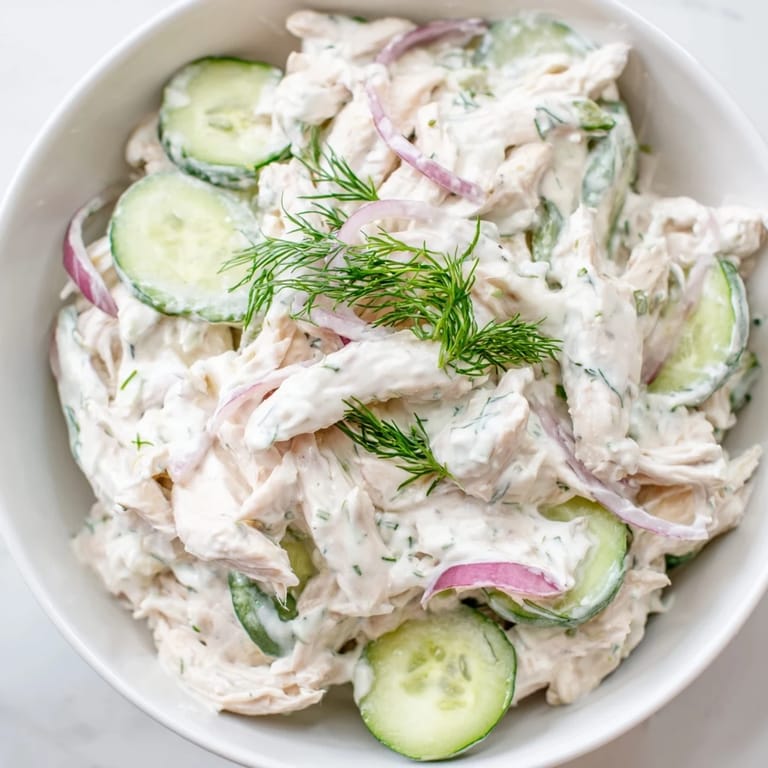 Spoonful of creamy Cucumber Chicken Salad with tender chicken and crisp veggies, garnished with fresh dill and green onions.  