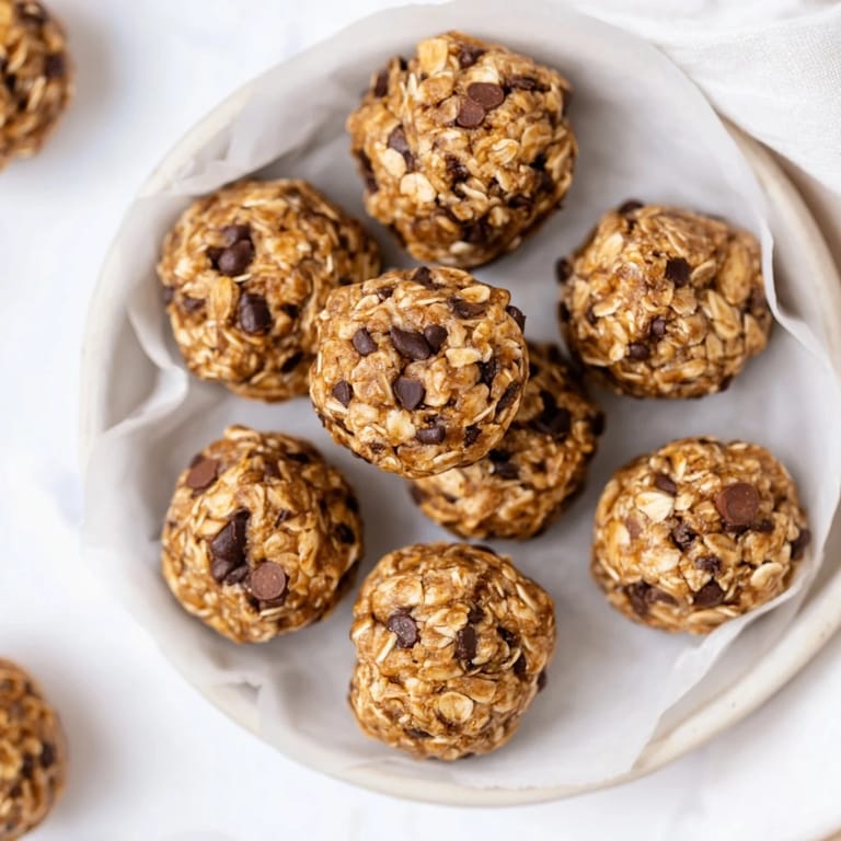 A no-bake Banana Chocolate Chip Energy Ball broken in half showing soft oats and chocolate chips.