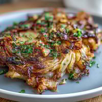 Air Fryer Crispy Cabbage Steaks with Garlic Butter, golden and caramelized, drizzled with savory garlic butter for a flavorful vegetarian side dish.