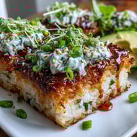 Crispy golden rice squares topped with creamy, spicy tuna and garnished with avocado slices.